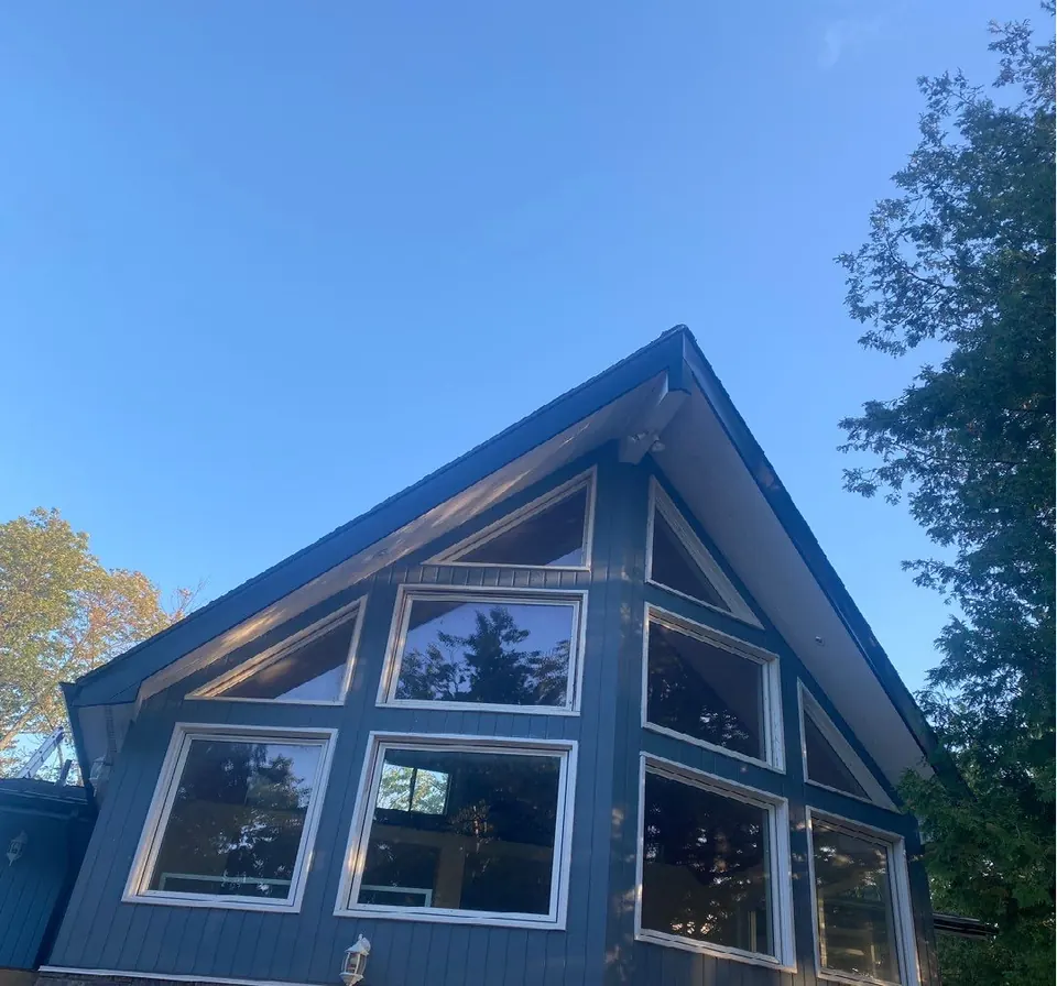 A tall A-frame house with a wall of windows under a steep roof
