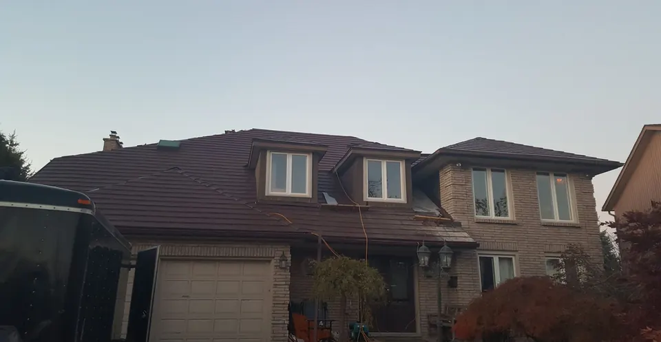 A finished roof on a brick two-storey house with dormers and a double garage